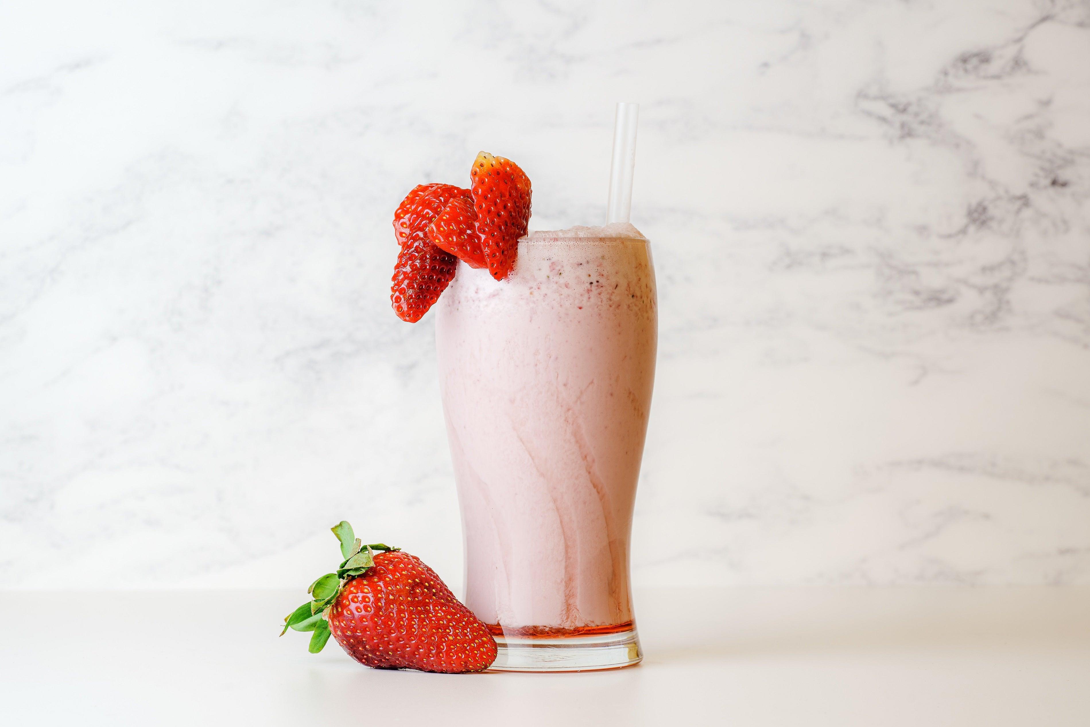 close up shot of strawberry milkshake with whipped cream In a